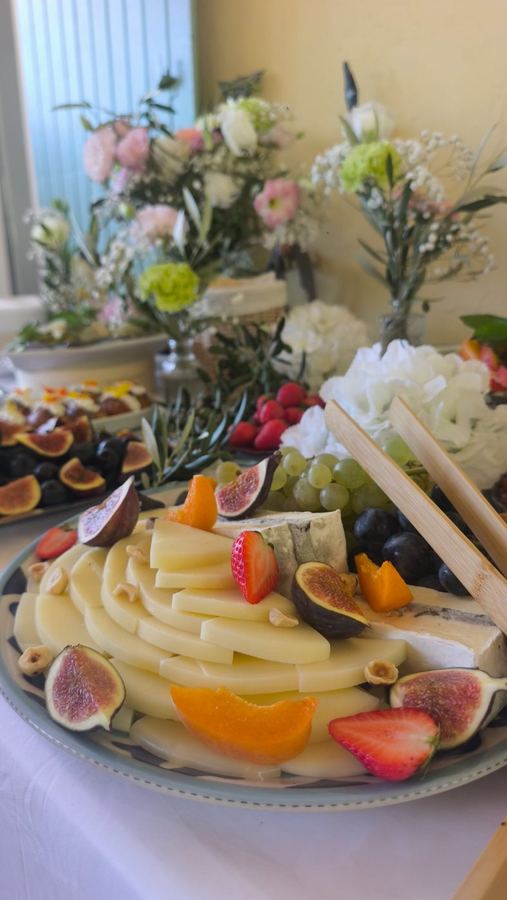 Buffet de baptême avec fromages italiens, figues et fleurs blanches