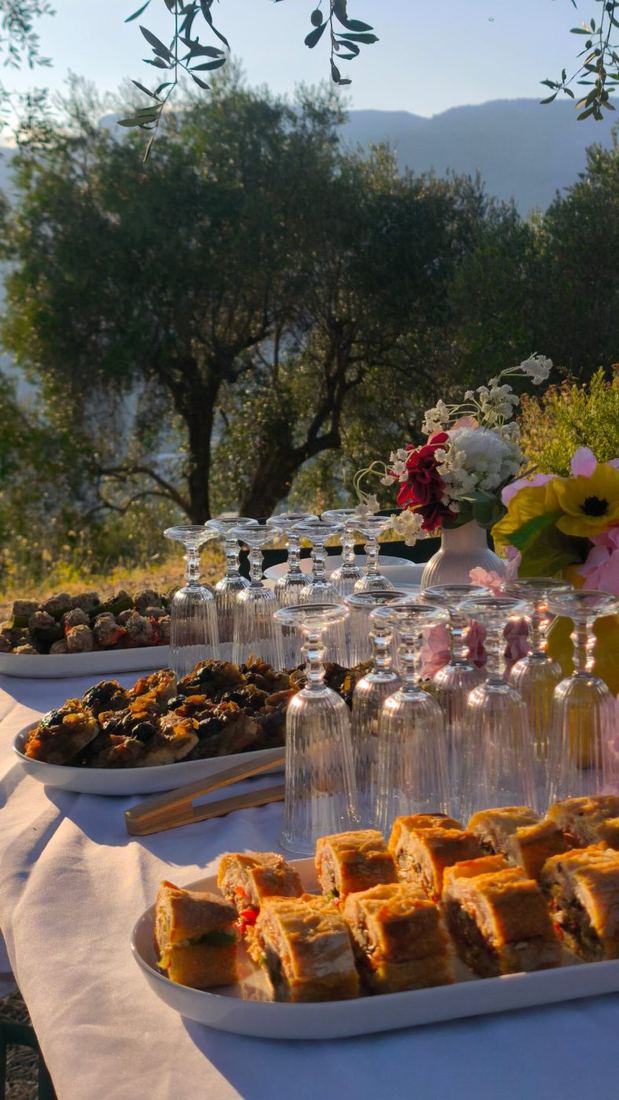 Table dressée sous les oliviers pour une réception Lazio Traiteur